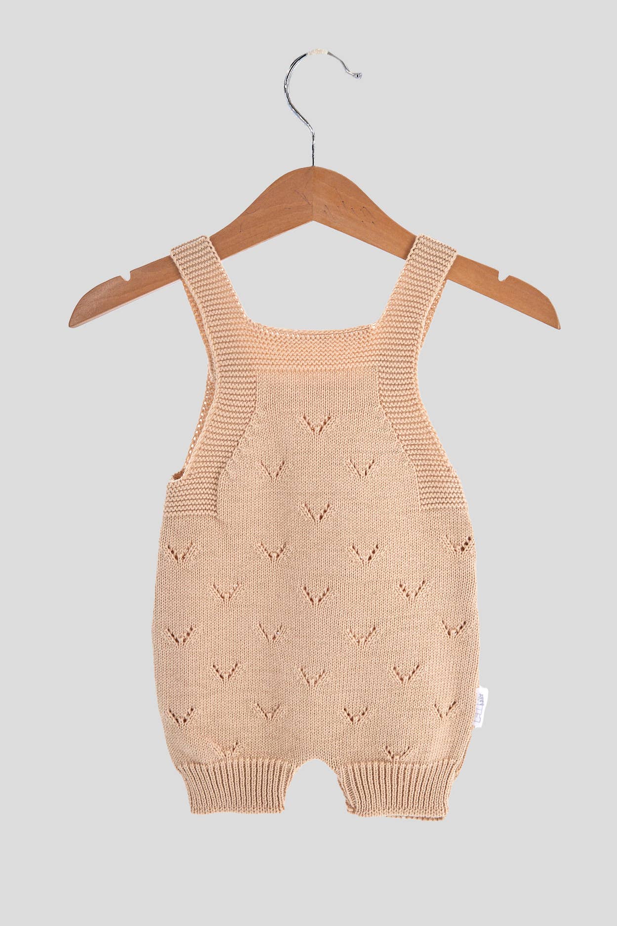 Knit jumpsuit in soft sand color, featuring a V pattern, perfect for babies aged 1-3M and 3-6M.