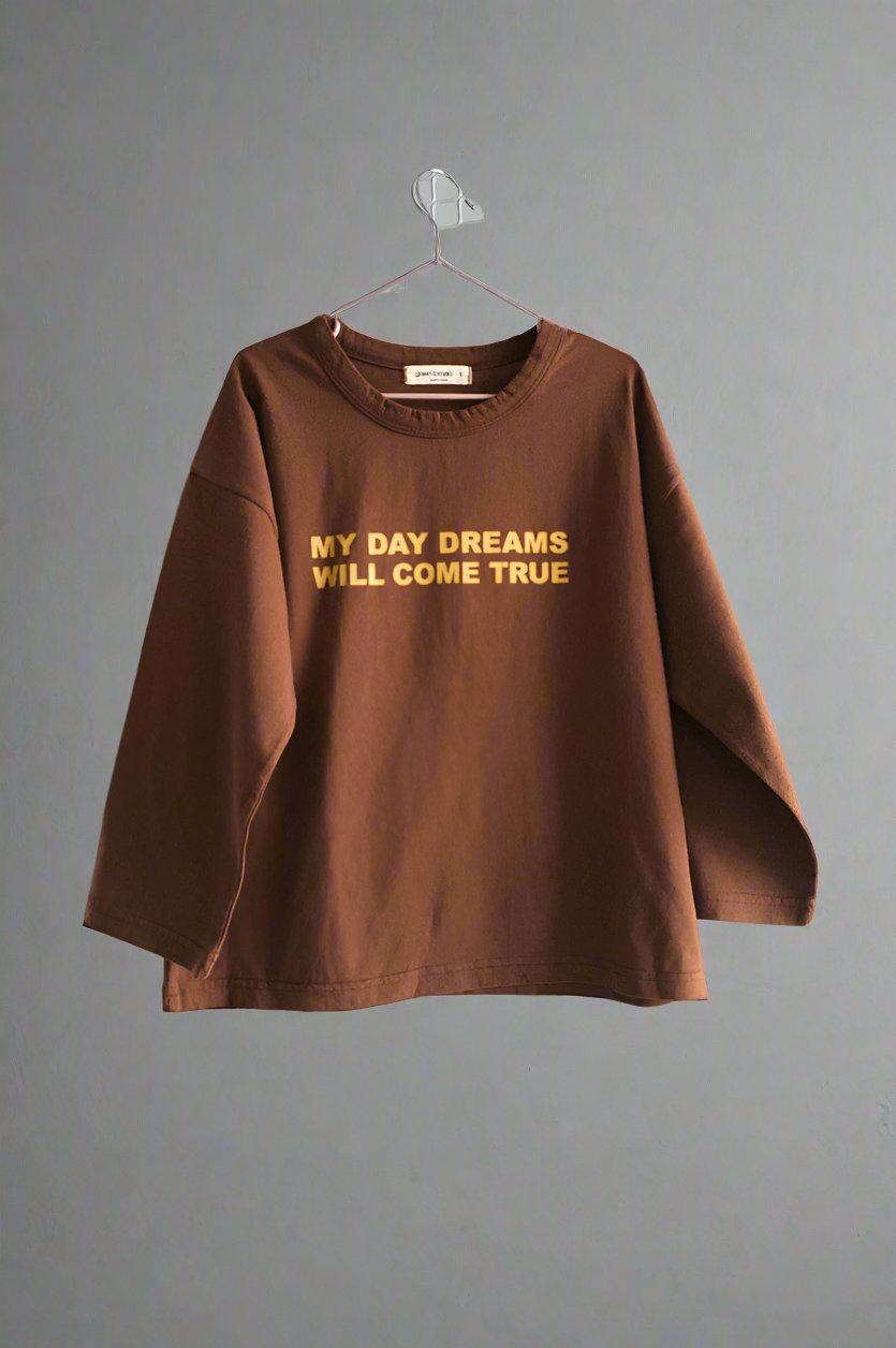 Chocolate long-sleeve tee with "My Day Dreams Will Come True" print, part of Every.Body selection, cozy fit for kids.